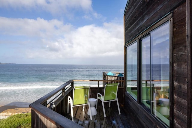 balcony featuring a beach view and a water view