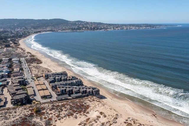 birds eye view of property with a water view and a beach view