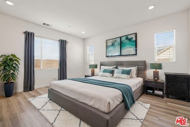 bedroom featuring light hardwood / wood-style floors and multiple windows