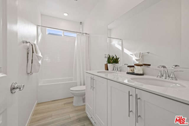 full bathroom featuring wood-type flooring, vanity, toilet, and shower / bath combination with curtain