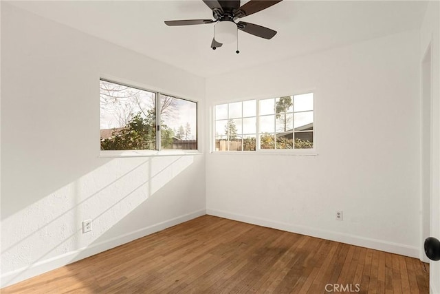 spare room featuring a wealth of natural light, hardwood / wood-style floors, and ceiling fan