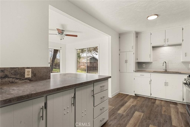 5690 Paradise Ave, Paradise, CA 95969 - kitchen with dark countertops, tasteful backsplash, ceiling fan, dark wood-type flooring, and white cabinetry