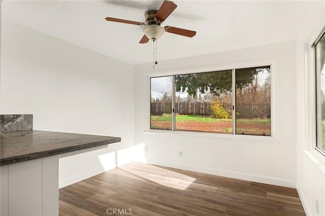 unfurnished dining area with dark hardwood / wood-style floors and ceiling fan