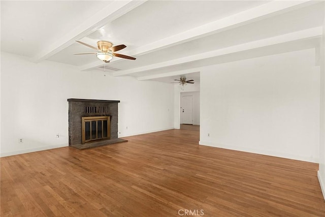 unfurnished living room featuring beamed ceiling, ceiling fan, wood-type flooring, and a fireplace