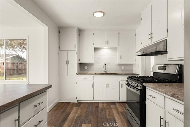 kitchen featuring sink, dark wood-type flooring, stainless steel gas range, decorative backsplash, and white cabinets