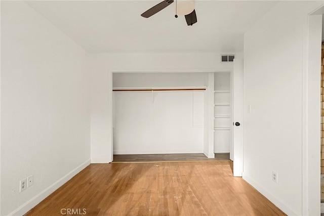 unfurnished bedroom with hardwood / wood-style floors, a closet, and ceiling fan