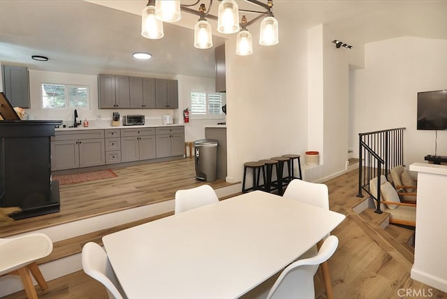 dining room featuring a notable chandelier, a healthy amount of sunlight, light hardwood / wood-style floors, and sink