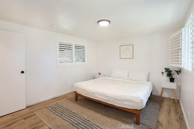 bedroom featuring light hardwood / wood-style flooring and multiple windows