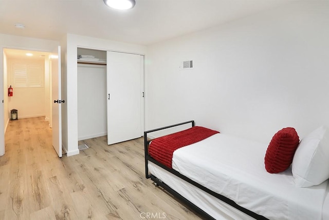 bedroom with a closet and light hardwood / wood-style flooring