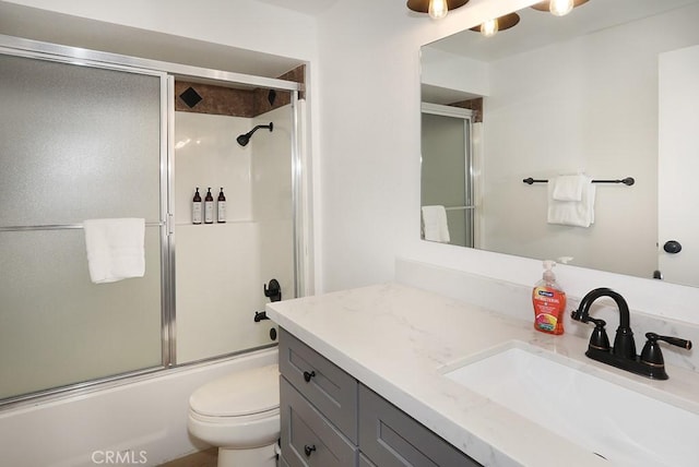 full bathroom featuring vanity, toilet, and bath / shower combo with glass door