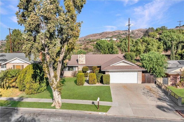 single story home featuring a garage and a front yard