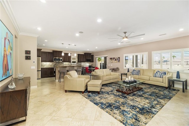 tiled living room with ceiling fan and ornamental molding