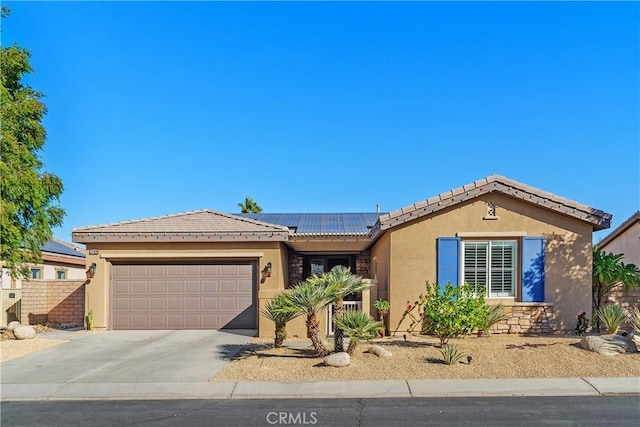 ranch-style house with a garage and solar panels