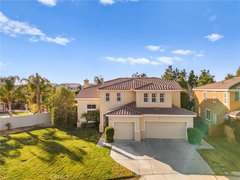 mediterranean / spanish-style home featuring a garage and a front yard