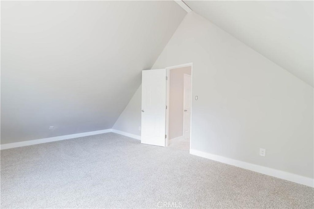 bonus room featuring light colored carpet and vaulted ceiling