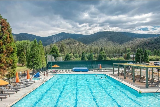 view of swimming pool featuring a patio and a mountain view