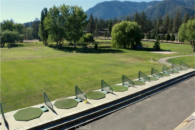 surrounding community with a mountain view and a lawn