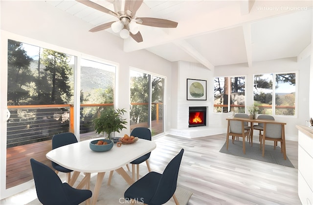 sunroom with beam ceiling and a fireplace