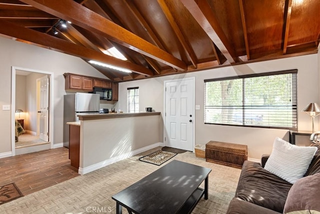 living room featuring vaulted ceiling with beams and light hardwood / wood-style flooring