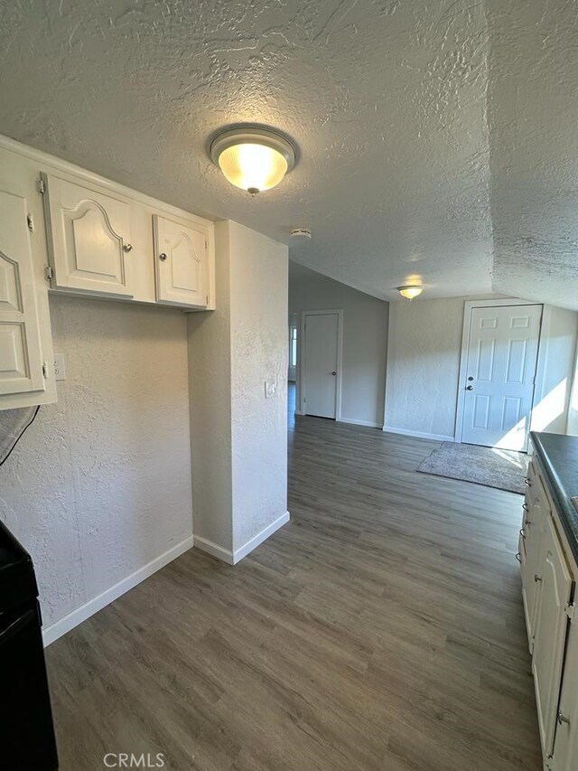 kitchen with white cabinetry, dark hardwood / wood-style floors, and a textured ceiling