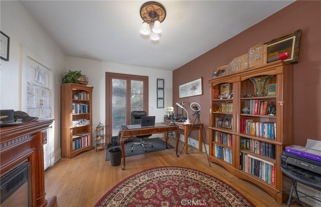 office space with a fireplace and light hardwood / wood-style floors