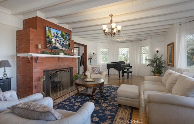 living room featuring a brick fireplace, beamed ceiling, a notable chandelier, and hardwood / wood-style flooring