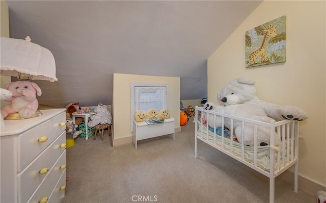 bedroom with a crib, light colored carpet, and vaulted ceiling