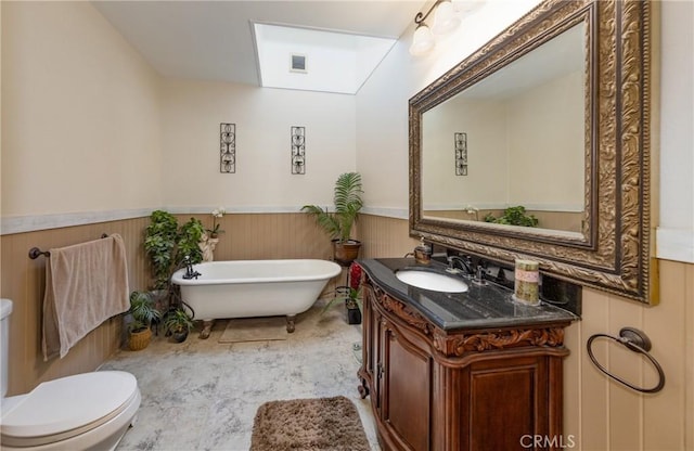 bathroom with vanity, wood walls, toilet, and a bath