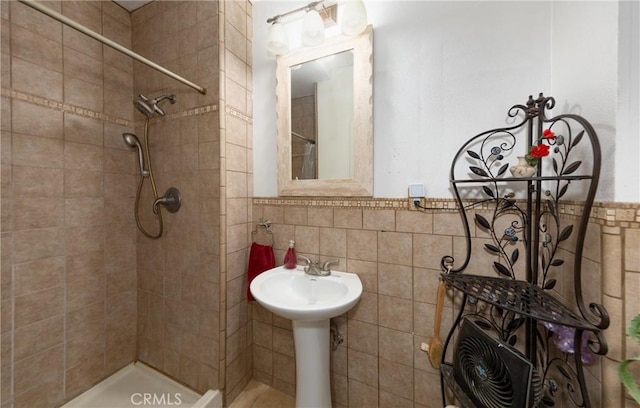 bathroom featuring tiled shower and tile walls