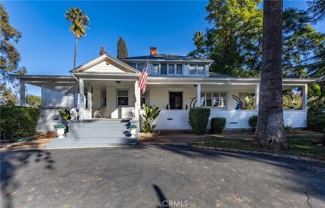 view of front facade featuring covered porch and a carport