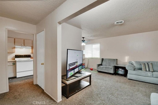 living area with light carpet, visible vents, and a textured ceiling