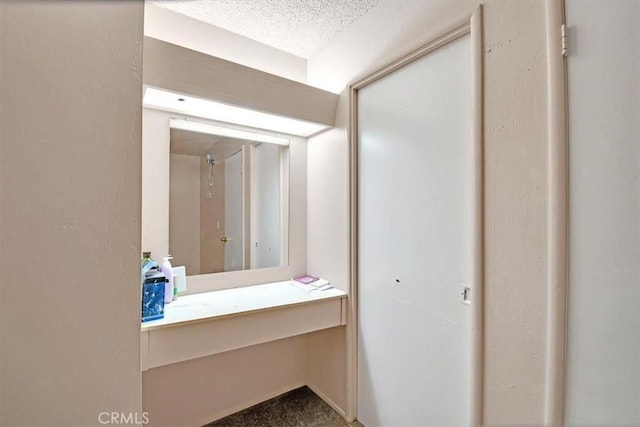 bathroom with a textured ceiling and vanity