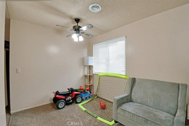 rec room featuring a ceiling fan, visible vents, a textured ceiling, and carpet flooring