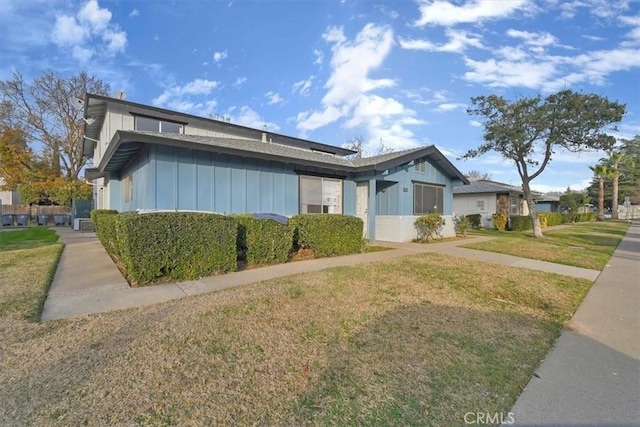 view of front of property with a front lawn and board and batten siding