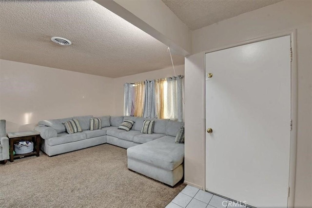 living room with light tile patterned floors, visible vents, and a textured ceiling