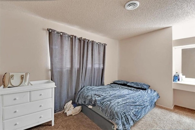 bedroom featuring a textured ceiling, carpet floors, and visible vents