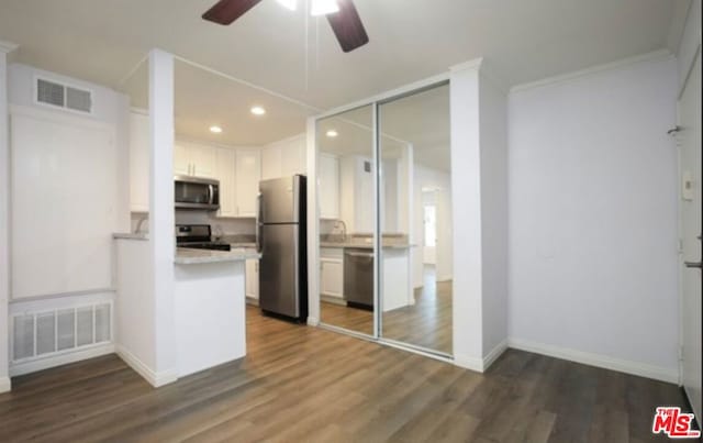 kitchen featuring white cabinets, dark wood-type flooring, and appliances with stainless steel finishes