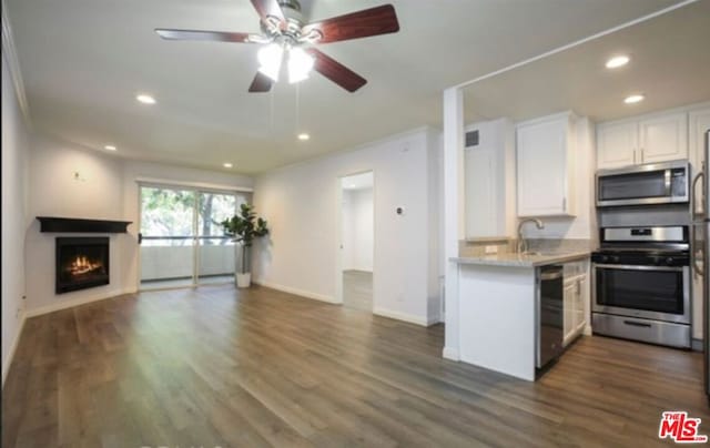 kitchen featuring sink, ceiling fan, appliances with stainless steel finishes, dark hardwood / wood-style flooring, and white cabinetry