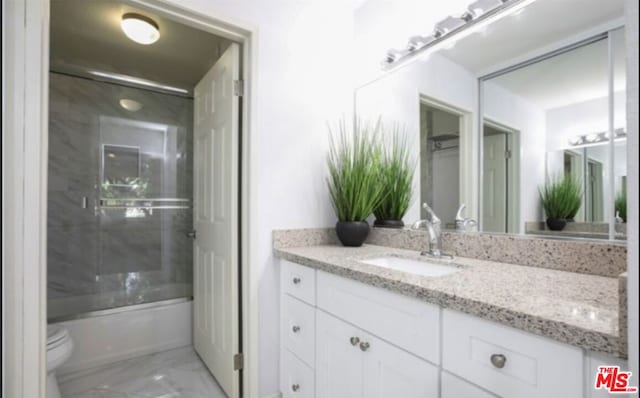 full bathroom with shower / bath combination with glass door, vanity, and toilet