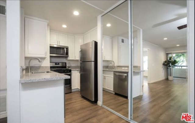 kitchen with white cabinets, stainless steel appliances, dark hardwood / wood-style floors, and sink