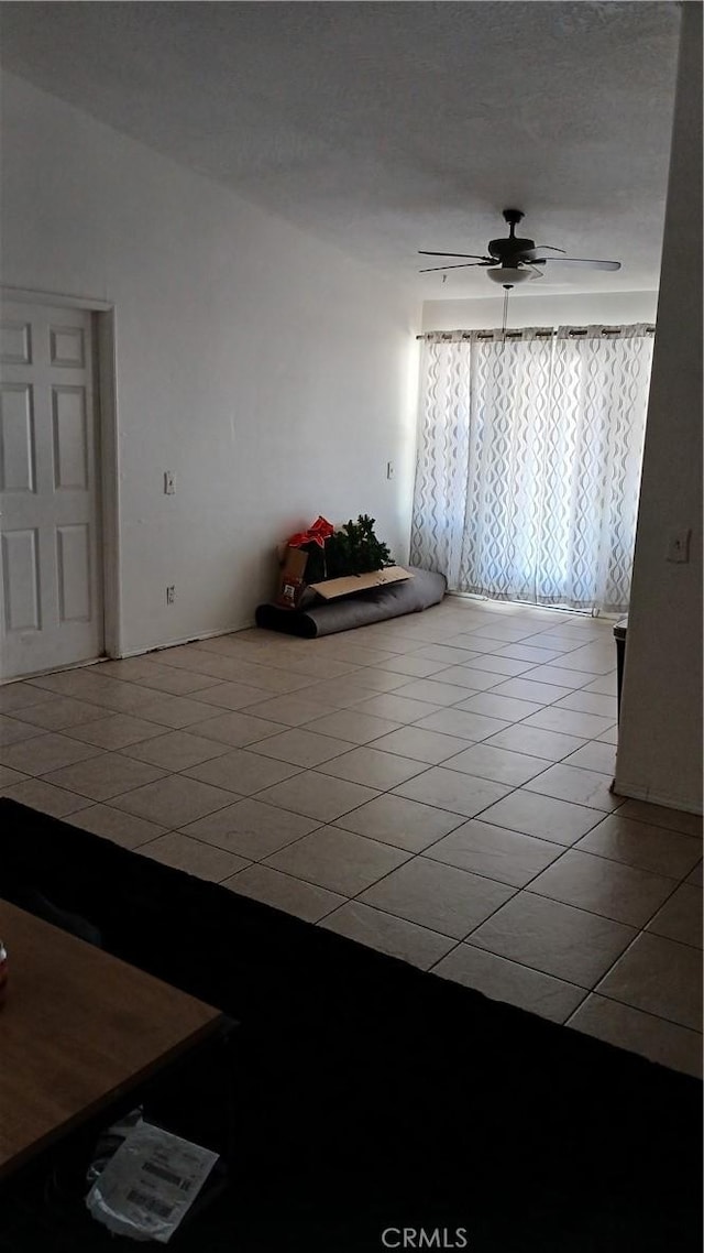 tiled spare room with ceiling fan