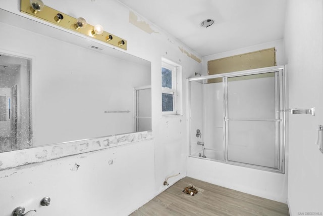 bathroom with wood-type flooring and shower / bath combination with glass door