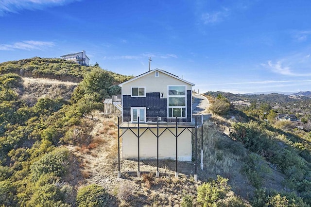 view of side of property featuring a balcony and a deck with mountain view