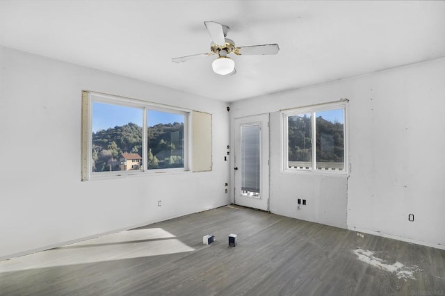 spare room featuring ceiling fan, a wealth of natural light, and hardwood / wood-style flooring