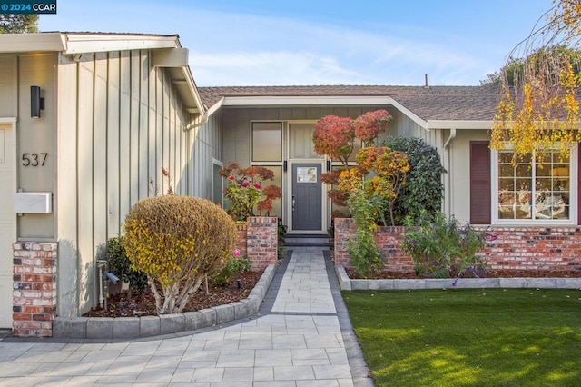 property entrance featuring a lawn