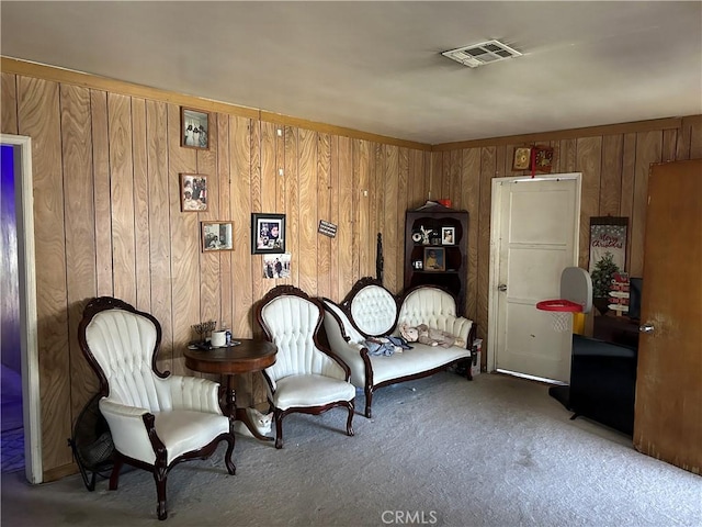 living area featuring carpet and wooden walls