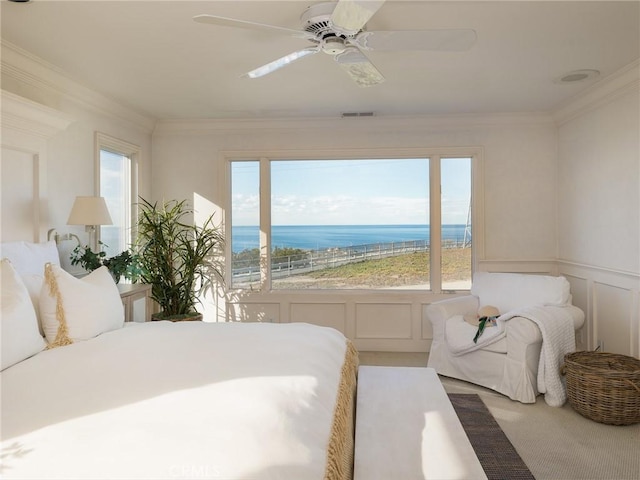 bedroom featuring carpet, multiple windows, ceiling fan, and a water view