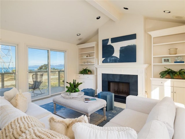 living room with a tile fireplace, lofted ceiling with beams, and plenty of natural light