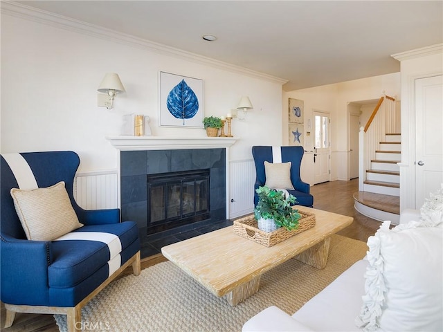 living room featuring a tile fireplace, dark hardwood / wood-style floors, and crown molding