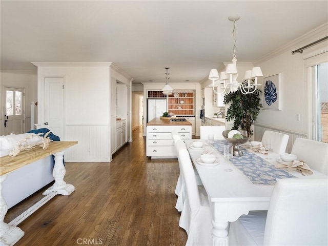 dining space with an inviting chandelier, dark hardwood / wood-style floors, and ornamental molding